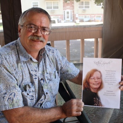A man holding a printed memorial keepsake